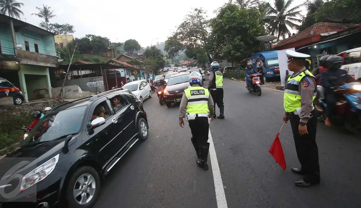 Petugas kepolisian mengatur arus lalu lintas di Simpang Nagreg, Jawa Barat, Sabtu (2/7). Polisi memberlakukan sistem rekayasa lalu lintas untuk menghindari kemacetan yang menuju ke Garut dan Tasik. (Liputan6.com/Immanuel Antonius)