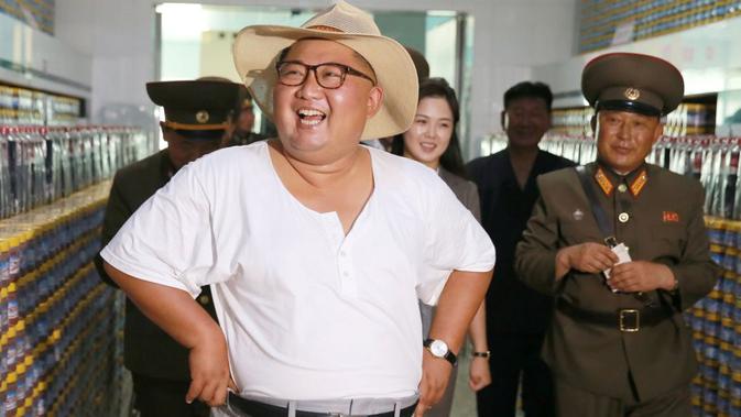 Gaya santai Pemimpin Korea Utara Kim Jong-un berbusana kaus oblong saat blusukan ke pabrik perikanan di Korea Utara (KCNA)