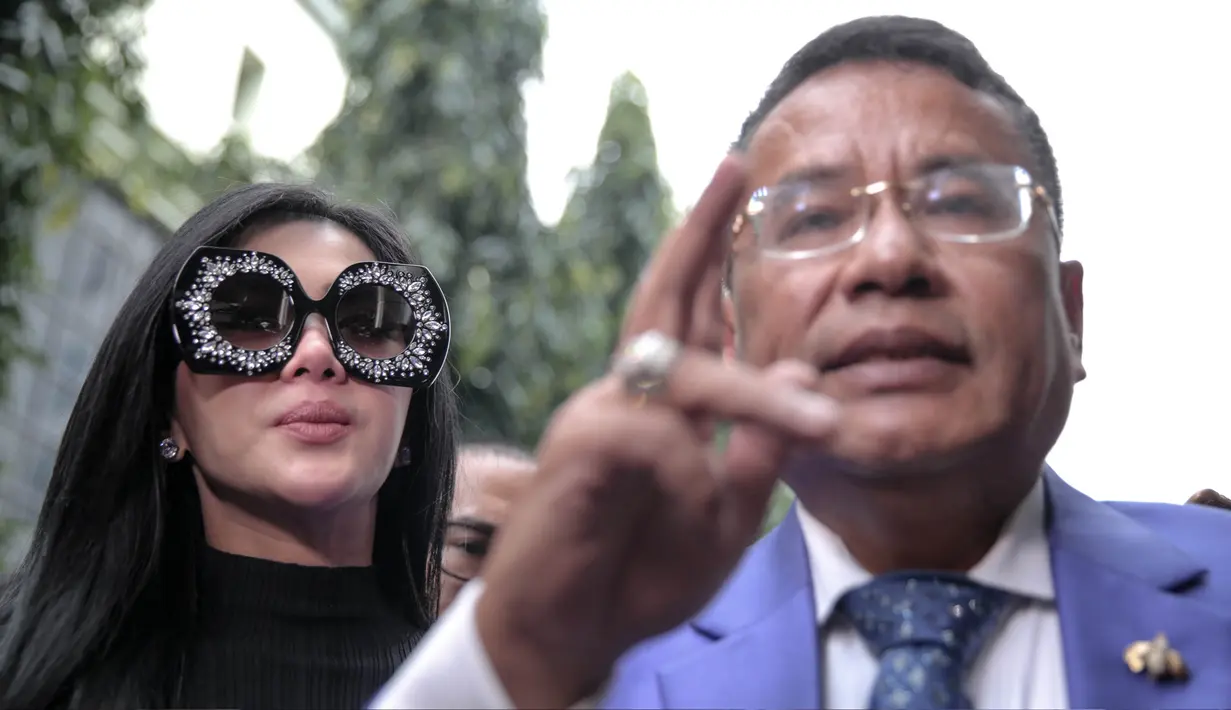 Penyanyi Syahrini enggan memberikan keterangan terkait kedatangannya memenuhi panggilan penyidik Bareskrim Polri, Jakarta, Senin (9/10). Meski tidak berkomentar, tapi Syahrini meladeni wartawan untuk dipotret. (Liputan6.com/Faizal Fanani)