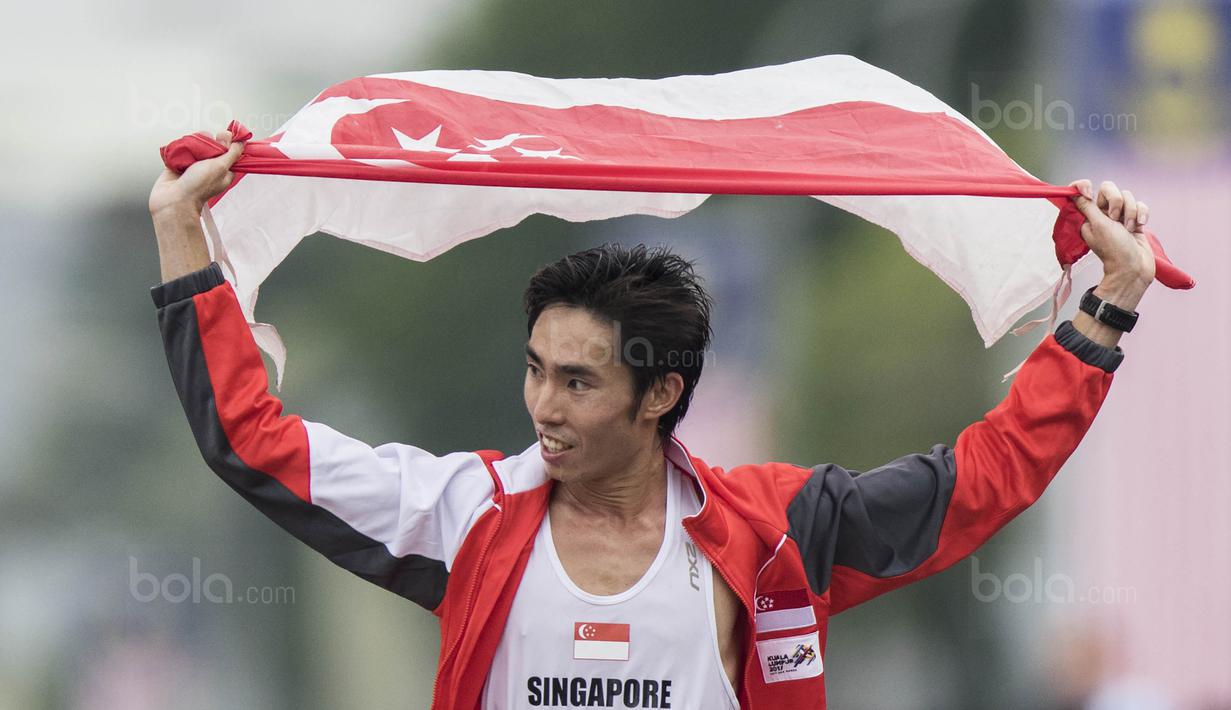 Pelari Singapura, Soh Rui Yong, melakukan selebrasi usai tampil pada nomor marathon SEA Games di Putrajaya, Kuala Lumpur, Sabtu (19/8/2017). Soh meraih medali emas dengan waktu dua jam 24 menit 55 detik. (Bola.com/Vitalis Yogi Trisna)