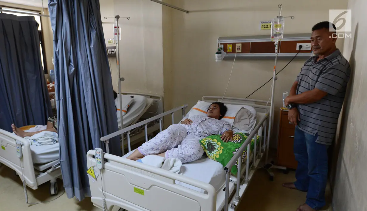 Seorang ayah menjaga anaknya yang terserang Demam Berdarah Dengue (DBD) yang dirawat di Rumah Sakit Umum Daerah (RSUD) Pasar Rebo, Jakarta, Jumat (1/2). Dalam sebulan ini, RSUD Pasar Rebo sudah menerima 88 pasien demam berdarah. (Merdeka.com/Imam Buhori)