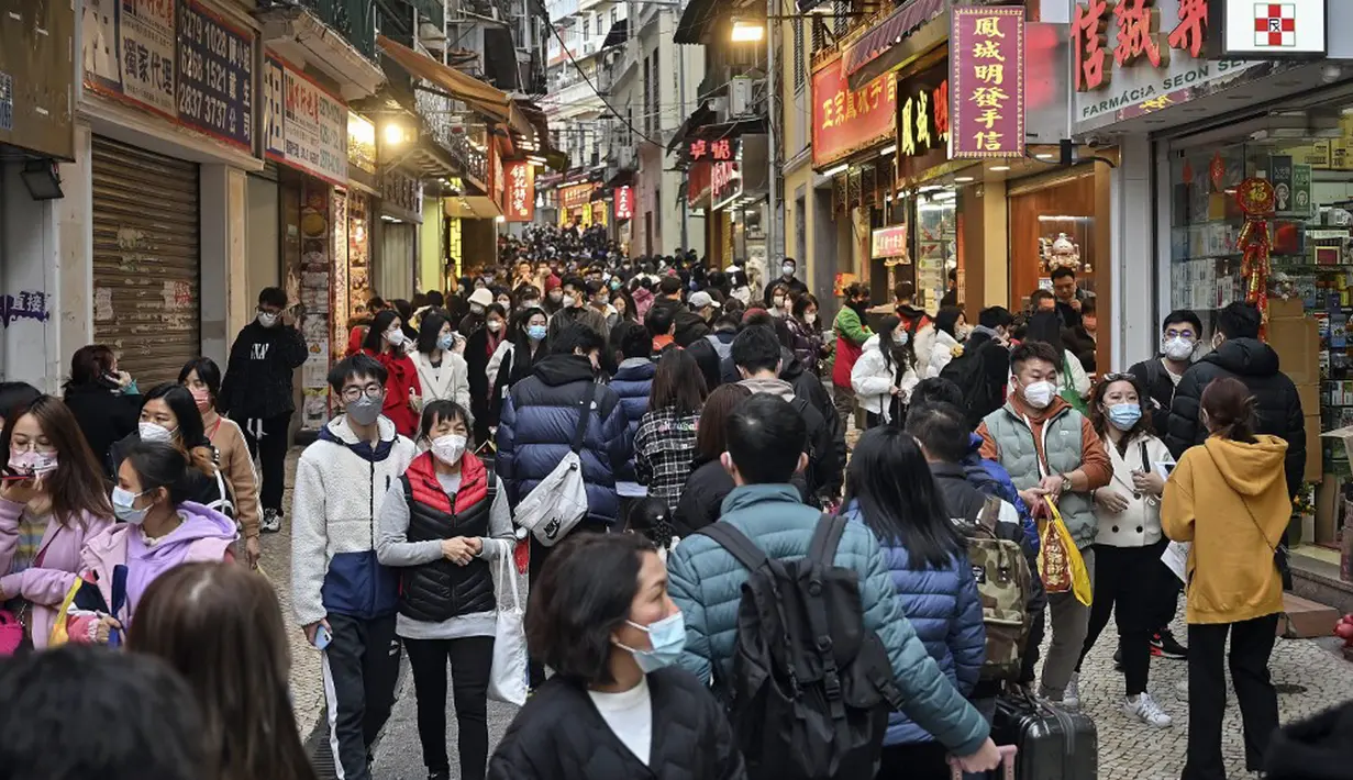 Pelancong asal China berjalan-jalan di daerah kantong China, Makau, 17 Januari 2023. Ledakan pariwisata China yang diharapkan selama liburan Tahun Baru Imlek minggu depan tampaknya akan lebih cepat terjadi. (Peter PARKS/AFP)