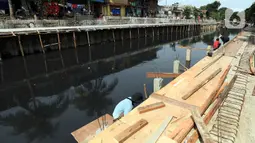 Pekerja mengerjakan proyek pembangunan tanggul bantaran Kali Anak Ciliwung di RT 001 RW 008 Ancol, Pademangan, Jakarta Utara, Kamis (19/12/2019). Pembangunan tanggul untuk mencegah amblesnya bantaran sungai seperti pada akhir tahun 2018 lalu. (Liputan6.com/Johan Tallo)