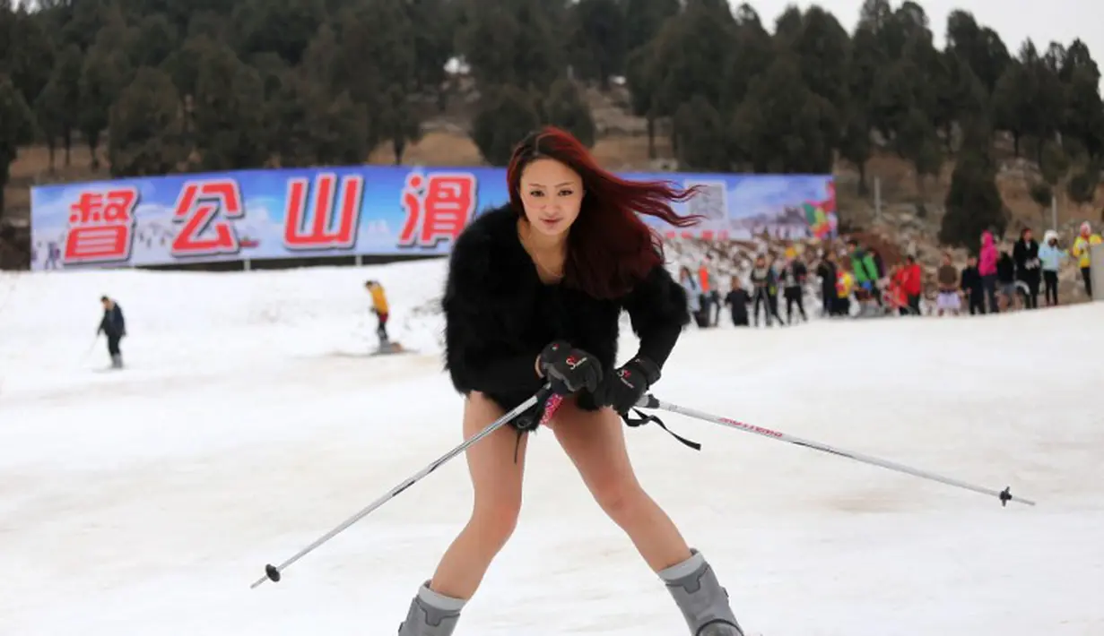Seorang wanita bermain ski tanpa mengenakan celana saat ikut berpatisipasi dalam No Pants Subway Ride di Dugongshan Ski Resort, Cina. Foto diambil Selasa (13/01/2015). (CHINA OUT AFP PHOTO)