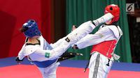 Atlet taekwondo putri Makau, Liu Qing melayangkan tendangannya ke arah Fitriyana Yusuf dari Indonesia pada babak 16 besar di Jakarta Convention Center (JCC), Senin (20/8). Fitriyana kalah tipis 21 - 25 pada kelas Wanita 67 kg. (Liputan6.com/Fery Pradolo)