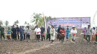 Menteri Pertanian Syahrul Yasin Limpo melakukan tebar benih padi di Desa Muara Telang, Kabupaten Banyuasin Sumsel (Liputan6.com / Nefri Inge)