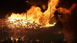 Anggota Jarl Squad membakar replika longship / kapal perang bangsa Viking saat festival Up Helly Aa Viking di Lerwick, Kepulauan Shetland, Skotlandia (31/1). Sedikitnya ada 5.000 wisatawan yang datang untuk menonton. (Jane Barlow/PA via AP)