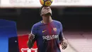 Bek anyar Barcelona, Yerry Mina mengontrol bola dengan kepalanya saat perkenalan dengan para fans Blaugrana di Stadion Camp Nou, Barcelona, Spanyol, Sabtu (13/1). Mina menerima kontrak berdurasi lima tahun hingga 2023. (Pau Barrena / AFP)