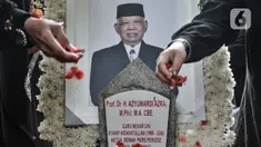 Warga menaburkan bunga saat berziarah ke makam Ketua Dewan Pers Azyumardi Azra di Taman Makam Pahlawan (TMP) Kalibata, Jakarta Selatan, Selasa (20/9/2022). Selain para tokoh dan cendekiawan, warga dari kalangan umum turut hadir di pemakaman Azyumardi Azra untuk berziarah sekaligus memberikan pengormatan terakhir. (merdeka.com/Iqbal S Nugroho)