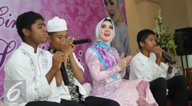 Penyanyi Syahrini saat buka puasa bersama dengan anak yatim piatu di Masjid Az-Zikra, Sentul, Bogor, Jumat (24/6). Syahrini berbagi rezeki dengan 5.000 anak yatim.  (Liputan6.com/Herman Zakharia)