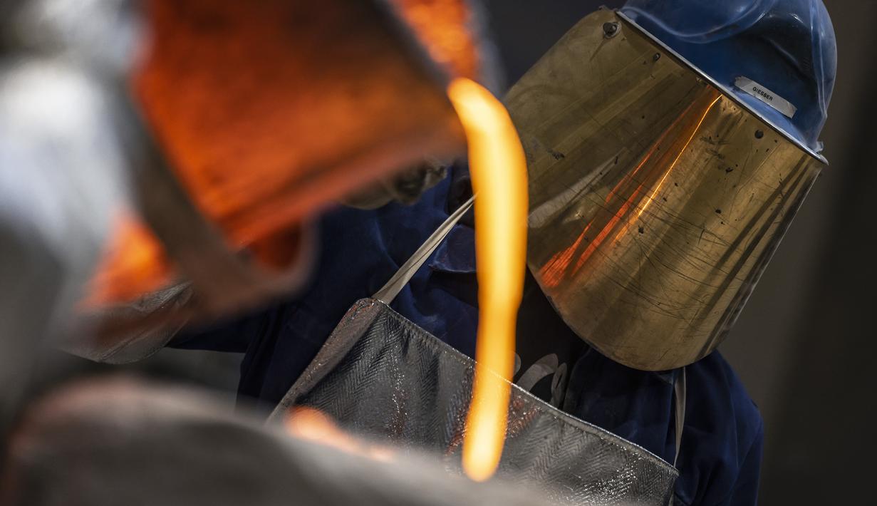 Pematung menuangkan logam cair untuk membuat medali dengan Beruang Berlinale, salah satu piala Festival Film Internasional Berlin di pengecoran Noack di Berlin, 25 Januari 2022. Kompetisi film Berlin edisi 2022 akan berlangsung dari 10 - 16 Februari secara tatap muka. (Hannibal Hanschke/POOL/AFP)