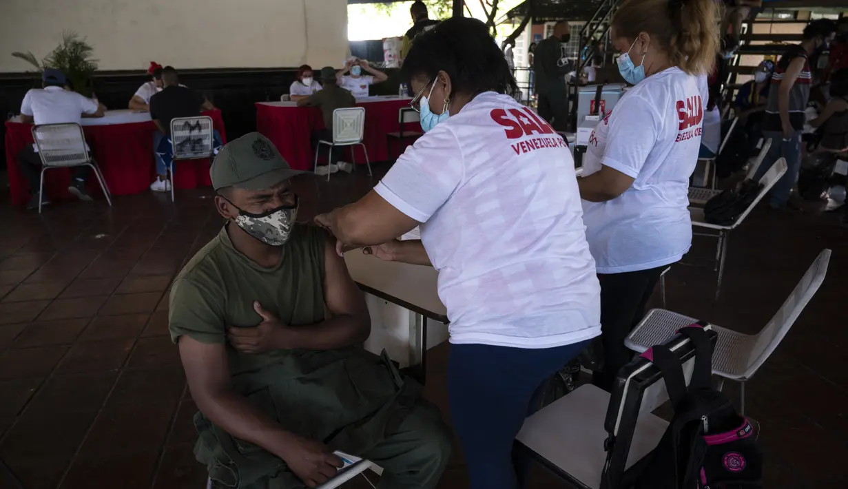 Reaksi tentara Venezuela ketika menerima dosis pertama kandidat vaksin Covid-19 Abdala buatan Kuba selama kampanye vaksinasi massal di Fuerte Tiuna, Caracas, Rabu (30/6/2021). Venezuela pada 24 Juni 2021 menandatangani kontrak untuk membeli 12 juta dosis vaksin Abdala. (Yuri CORTEZ/AFP)