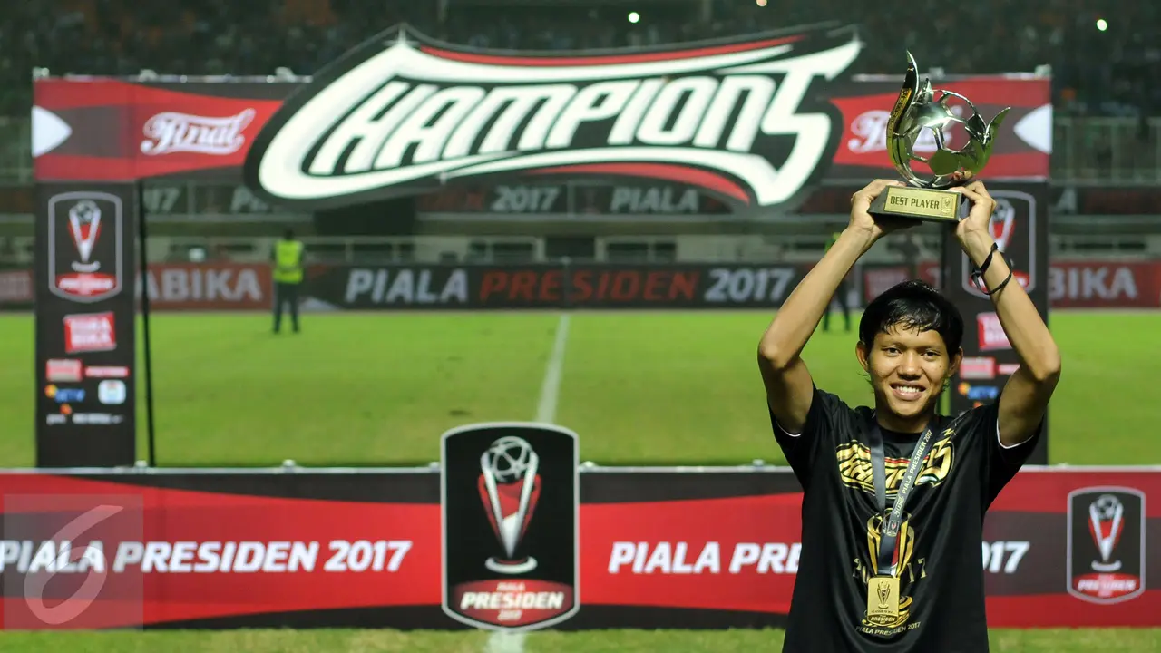 Gelandang Arema FC, Adam Alis, mengangkat trofi pemain terbaik Piala Presiden 2017. 