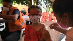 Petugas kesehatan menyuntik vaksin covid-19 kepada seorang anak di San Lorenzo, Paraguay, Senin (31/1/2022). Paraguay mulai memvaksinasi anak-anak berusia 5 hingga 11 tahun pada hari Senin, karena peningkatan tajam infeksi covid-19 yang didorong oleh varian omicron. (NORBERTO DUARTE / AFP)