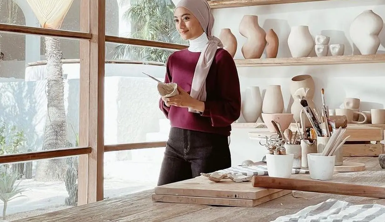 Cocok untuk outfit kuliahan nih! Padukan sweater merah maroon dengan inner dan high waist pants warna hitam. Agar makin stylish, padukan dengan hijab cream yang ditata turban seperti look Ayudia Bing Slamet ini. (Instagram/ayudiac).