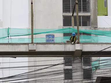 Pekerja menyelesaikan pembangunan JPO Pasar Rumput di Jakarta, Selasa (15/1). Pembangunan jembatan di bangunan pasar yang terintegrasi dengan rusun tersebut dibuat untuk memudahkan mobilitas warga. (Liputan6.com/Immanuel Antonius)