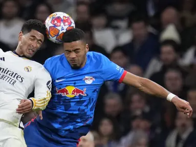 Pemain Real Madrid, Jude Bellingham (kiri) berduel udara dengan pemain RB Leipzig, Benjamin Henrichs pada laga leg kedua 16 besar Liga Champions 2023/2024 di Santiago Bernabeu, Madrid, Spanyol, Kamis (07/03/2024) WIB. (AP Photo/Manu Fernandez)