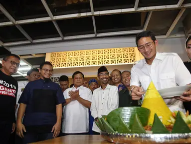 Wakil Gubernur Sandiaga Uno memotong tumpeng saat peresmian sekretariat bersama Partai Gerindra - PKS dan PAN di Jakarta, Jumat (27/4). Dalam acara ini turut hadir Ketua Umum Partai Gerindra Prabowo Subianto. (Liputan6.com/JohanTallo)