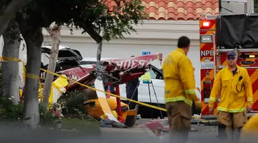 Polisi menyelidiki helikopter yang jatuh menghantam sebuah rumah di Newport Beach, California, Selasa (30/1). Lima orang terlibat kecelakaan termasuk empat orang yang berada di helikopter dan satu pejalan kaki. (Allen J. Schaben/Los Angeles Times via AP)