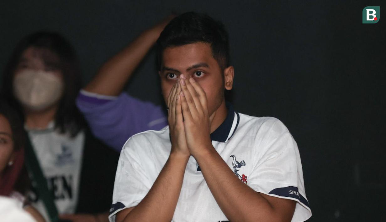 Ekspresi tegang seorang penggemar Tottenham Hotspur saat menyaksikan tim kesayangannya menghadapi Arsenal dalam acara nonton bareng Roaring Night Liga Inggris 2023/2024 di Treehaus Kemang, Minggu (28/4/2024) malam WIB yang digelar komunitas penggemar Tottenham Hotspur, IndoSpurs Jakarta. (Bola.com/Abdul Aziz)