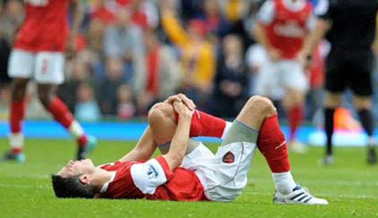 Striker Arsenal Robin van Persie tergeletak kesakitan akibat cedera lutut yang dialaminya di laga lanjutan EPL melawan Blackburn Rovers di Ewood Park, 28 Agustus 2010. AFP PHOTO / ANDREW YATES