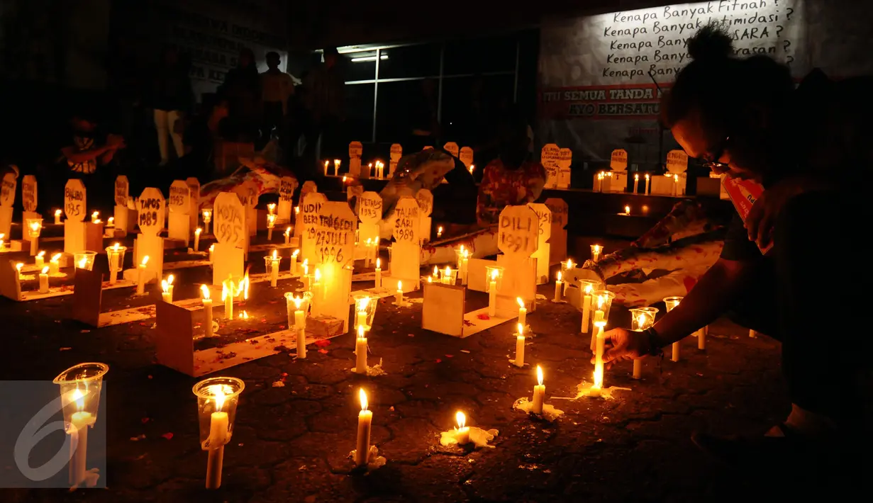 Aktivis menyalakan lilin diantara replika nisan korban pelanggaran HAM masa lalu saat peringatan 19 tahun reformasi di Galeri Cipta 2 TIM, Jakarta, Jumat (12/5). Para aktivis juga menyanyikan lagu perjuangan. (Liputan6.com/Helmi Fithriansyah) 