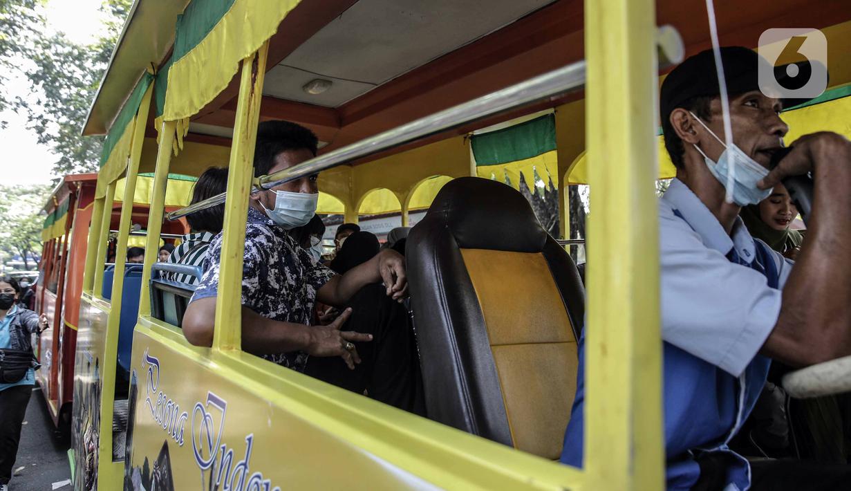 Pengunjung naik kendaraan wisata di Taman Mini Indonesia Indah (TMII), Jakarta, Sabtu (15/5/2021). Selama libur Lebaran, pengelola TMII memberlakukan protokol kesehatan secara ketat. (Liputan6.com/Faizal Fanani)