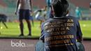 Seorang pekerja tengah serius menyaksikan para pemain Arema FC berlatih di Stadion Pakansari, Bogor, Jumat (10/3/2017). Arema FC akan melawan Pusamania Borneo FC pada laga Final Piala Presiden 2017. (Bola.com/Nicklas Hanoatubun)