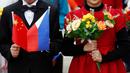 Sepasang anak-anak memegang bunga plastik dan bendera nasional Tiongkok dan Filipina pada saat menyambut kedatangan Presiden Filipina, Rodrigo Duterte di Balai Agung Rakyat Tiongkok, Beijing (20/10). (Reuters/Thomas Peter)