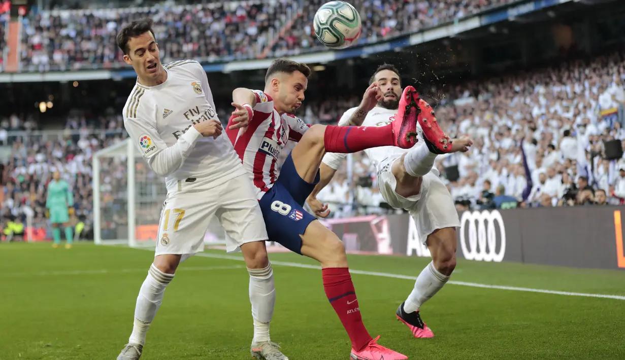 Gelandang Atletico Madrid, Saul Niguez (tengah) berebut bola dengan dua pemain Real Madrid,  Lucas Vazquez dan Dani Carvajal pada pertandingan lanjutan La Liga Spanyol di stadion Santiago Bernabeu di Madrid, Sabtu, (1/2/2020). Real Madrid menang tipis 1-0 atas Atletico Madrid. (AP Photo/Bernat Arman