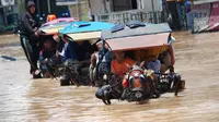 Sejumlah warga menggunakan jasa transportasi delman berusaha melintasi genangan banjir di kawasan Dayeuhkolot, Kabupaten Bandung, Jabar. (Antara/Fahrul Jayadiputra)