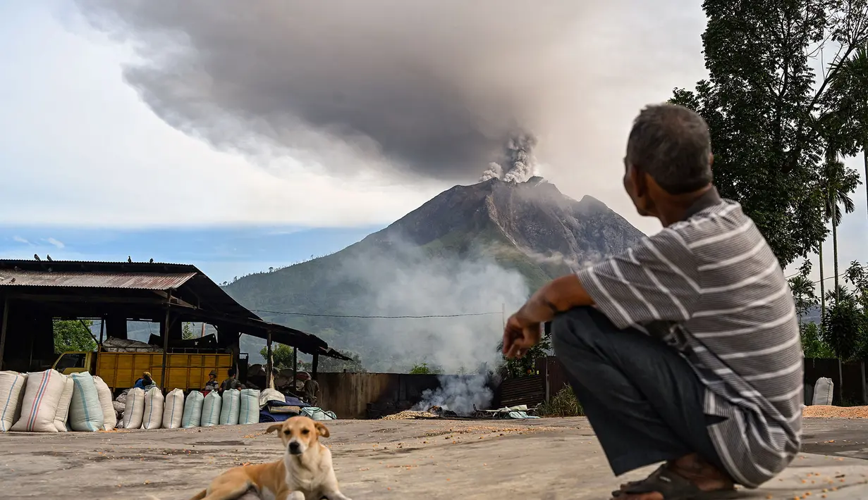 Warga menyaksikan Gunung Sinabung menyemburkan abu dan asap tebal dari wilayah Karo, Provinsi Sumatra Utara, Rabu, 2 September 2026. (AFP/ YT Haryono)