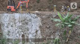 Aktivitas pekerja saat menyelesaikan proyek pembangunan saringan sampah Kali Ciliwung segmen Jalan TB Simatupang, Jakarta, Minggu (12/2/2023). Proyek Saringan Sampah senilai Rp 195 miliar ini awalnya ditargetkan rampung pada Januari 2023. Karena terhambat pembebasan lahan, Pemprov DKI akhirnya mengundur waktu pengerjaan hingga Maret mendatang. (merdeka.com/Iqbal S Nugroho)