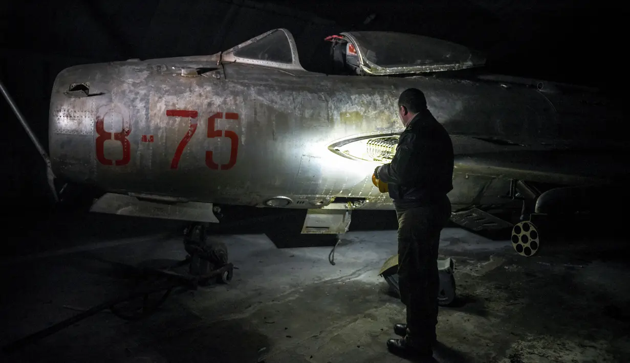 Pilot jet tempur Albania dan mantan komandan angkatan udara Fatmir Danaj (52) memeriksa jet tempur MiG-19 dalam terowongan utama Pangkalan Udara Gjader di dekat Kota Lezhe, 5 Februari 2019. (Gent Shkullaku/AFP)