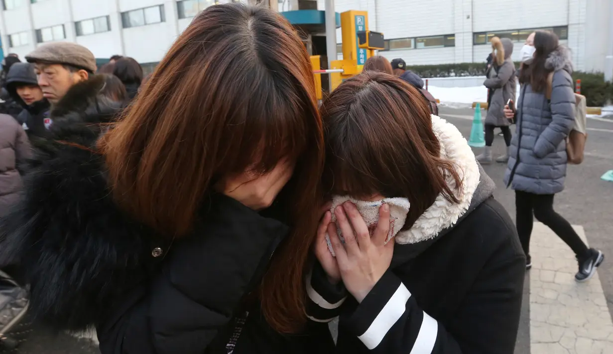 Tangis fans saat mobil yang membawa jenazah Jonghyun SHINee keluar dari rumah persemayaman di Asan Hospital, Seoul menuju tempat pemakaman, Kamis (21/12). Di antara para pelayat tampak pula artis-artis dari SM Entertainment. (AP/Ahn Young-joon)