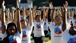 Sejumlah peserta mengikuti latihan yoga di Lapangan Independen di Kuala Lumpur, Malaysia (2/7). Acara yang merupakan perayaan Hari Yoga Sedunia dihadiri oleh Wakil Menteri Wilayah Persekutuan, Datuk Loga Bala Mohan. (AP Photo / Daniel Chan)