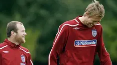 Wayne Rooney and Peter Crouch share a joke as they walk to the training ground for training at London Colney, North London, on October 7, 2008. AFP PHOTO/Glyn Kirk