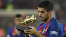 Striker Barcelona, Luis Suarez, menunjukan Sepatu Emas jelang laga La Liga melawan Granada di Stadion Nou Camp, Spanyol, Sabtu (29/10/2016). Suarez meraih gelar ini usai mencetak 40 gol pada musim lalu. (AFP/Lluis Gene)