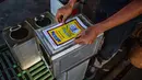 Pekerja menempelkan stiker pada kaleng di Pabrik Kopi Antong, Taiping, Perak, Malaysia, 29 September 2020. Pabrik Kopi Antong menggunakan mesin antik dan metode pemanggangan tradisional untuk menghasilkan bubuk sarat kafein yang terkenal selama 87 tahun. (Mohd RASFAN/AFP)