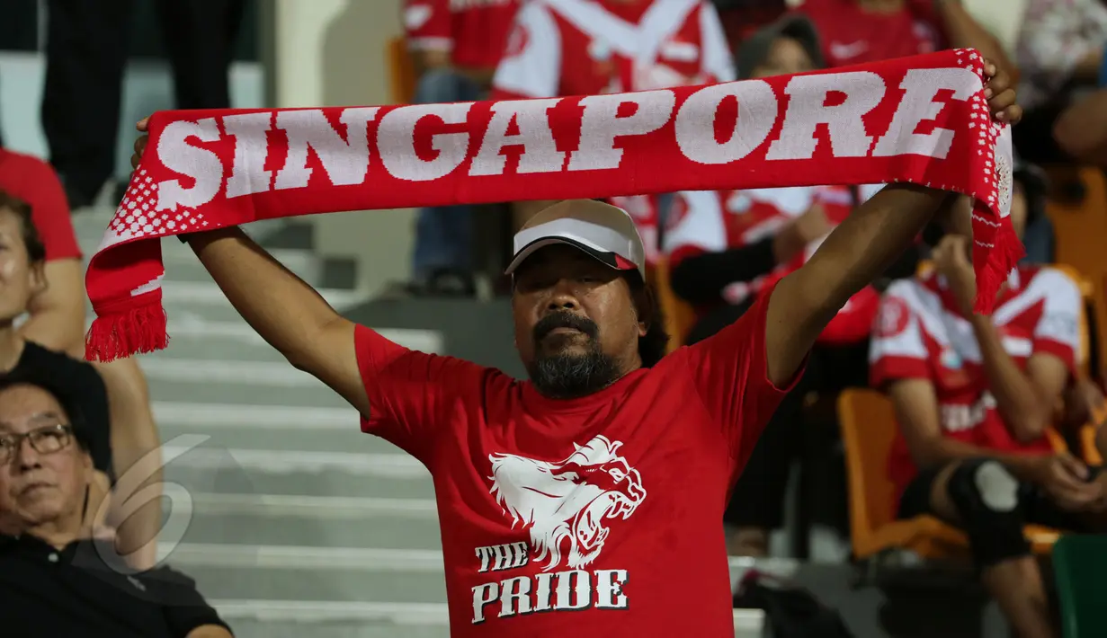 Salah satu suporter membentang syal saat menyaksikan laga timnas Singapura U-23 melawan Filipina di penyisihan grup A Sea Games 2015 di Stadion Jalan Besar, Singapura, Senin (1/6/2015). Singapura unggul 1-0. (Liputan6.com/Helmi Fithriansyah)