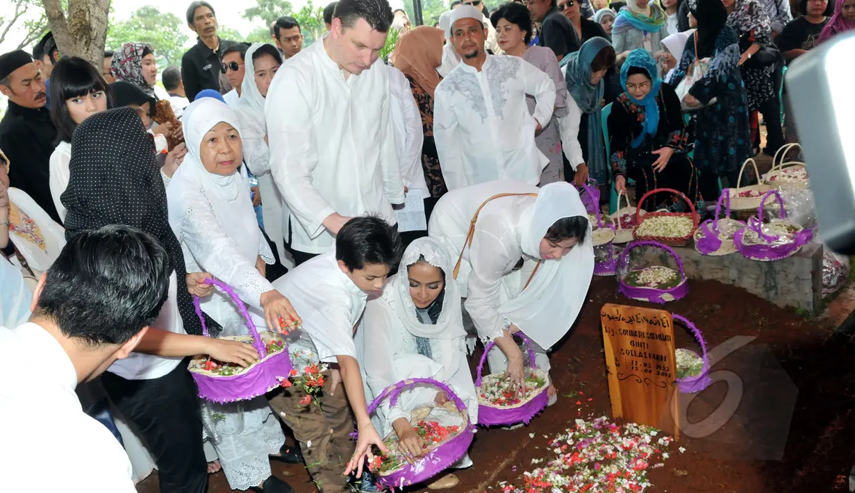 Maudy Koesnaedi didampingi suami serta sanak saudara menaburkan bunga di atas makam sang ibunda, Sondari Soemijati di TPU Karet Bivak, Jakarta, Kamis (16/4/2015). Ibunda Maudy meninggal Rabu sore (15/4) pada usia 82 ahun. (Liputan6.com/Panji Diksana)