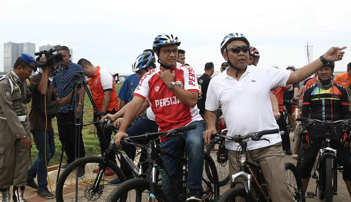 Gubernur DKI Jakarta Anies Baswedan bersepeda di kawasan Pantai Kita dan Pantai Maju, Minggu (23/12). Anies bersepeda santai ke lokasi acara peletakkan batu pertama di jalur jalan sehat dan sepeda santai (Jalasena). (Liputan6.com/Herman Zakharia)