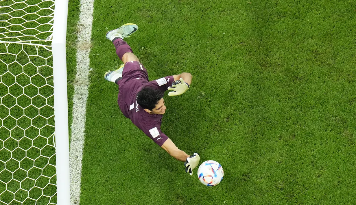 Kiper Maroko Yassine Bounou menyelamatkan tendangan penalti dari pemain Spanyol pada babak 16 besar Piala Dunia 2022 di Education City Stadium, Al Rayyan, Rabu (6/12/2022) dini hari WIB. Maroko tampil tangguh untuk merebut tiket perempat final dari Spanyol. (AP Photo/Petr David Josek)