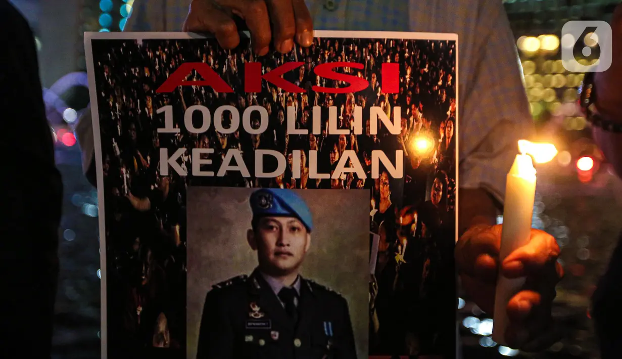 Massa aksi yang tergabung dalam Tim Advokat Penegak Hukum dan Keadilan (Tampak) menunjukkan poster bergambar Brigadir Yosua Hutabarat atau Brigadir J saat aksi 1000 lilin atas kematiannya di Bundaran HI, Jakarta, Jumat (22/7/2022). Aksi tersebut sebagai bentuk keadilan terkait kematian Brigadir J yang diduga akibat penyiksaan. (Liputan6.com/Faizal Fanani)