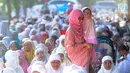 Seorang wanita menggendong anak usai melaksanakan salat Idul Fitri di kawasan Pelabuhan Sunda Kelapa, Jakarta, Rabu (5/6/2019). Umat muslim seluruh Indonesia merayakan Hari Raya Idul Fitri 1440 Hijriah setelah sebelumnya melaksanakan puasa Ramadan selama sebulan penuh. (merdeka.com/Arie Basuki)