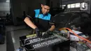 Pelajar SMK Negeri 26 Jakarta melakukan pengecekan instalasi part konversi mobil listrik di Bengkel Otomotif SMKN 26, Jakarta, Rabu (13/5/2023). (merdeka.com/Imam Buhori)