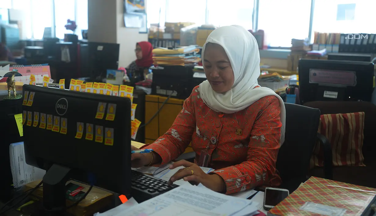 Seorang pegawai melakukan aktivitasnya saat mulai masuk kerja usai libur Lebaran di Balai Kota DKI Jakarta, Rabu (21/6). Usai halalbihalal, pegawai Pemprov DKI mulai berkerja normal. (Merdeka.com/Imam Buhori)