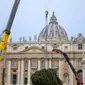 Sebuah derek mengangkat pohon cemara berusia 113 tahun dan setinggi 28 meter di Lapangan Santo Petrus, untuk dijadikan pohon Natal, di Vatikan, Selasa (23/11/2021). Hadiah dari kota Andalo di timur laut Italia itu akan menyala pada 10 Desember mendatang. (AP Photo/Andrew Medichini)