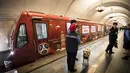 Petugas polisi dengan anjing berdiri dekat kereta Metro bertema Piala Dunia 2018 pada upacara pembukaan di Moskow, Selasa (28/11). Nuansa merah mendominasi kereta yang menjadi transportasi resmi perhelatan Piala Dunia 2018 tersebut. (Mladen ANTONOV/AFP)