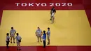 Para juri, relawan, dan teknisi bekerja di dalam venue Nippon Budokan untuk pertandingan judo dan karate selama Olimpiade Tokyo 2020 di Tokyo pada 21 Juli 2021. (AFP/Franck Fife)